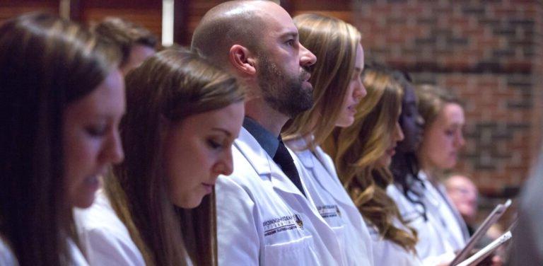 HSU Physician Assistant students dressed in white lab coats listening to a lecture